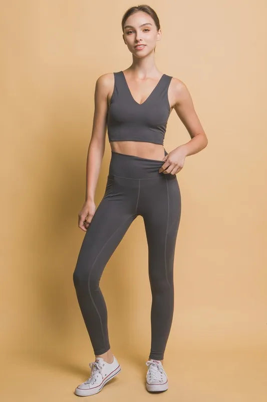 Woman wearing the Her Femme Fit High-Rise Leggings in Dark Grey