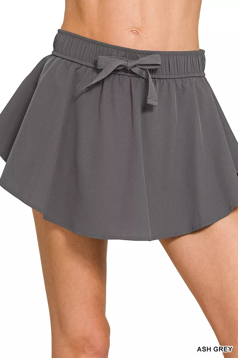 Woman wearing the Her Femme Fit Soft Woven Active Skort in Ash Grey