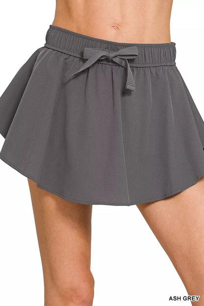 Woman wearing the Her Femme Fit Soft Woven Active Skort in Ash Grey