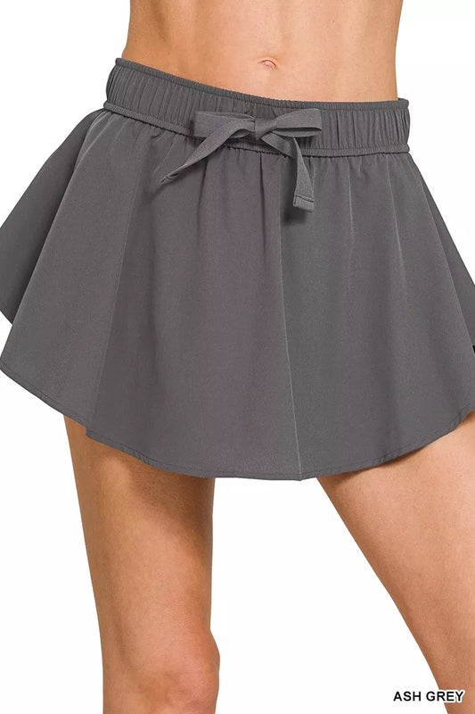 Woman wearing the Her Femme Fit Soft Woven Active Skort in Ash Grey