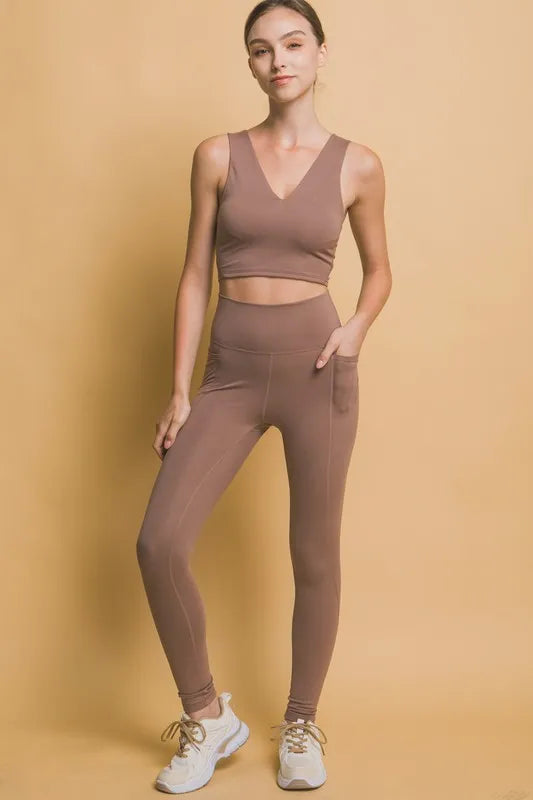 Woman wearing the Her Femme Fit High-Rise Leggings in Taupe