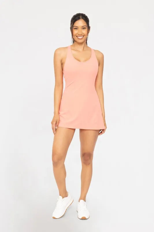 Woman wearing the Her Femme Fit Twist Racerback Active Dress in Watermelon