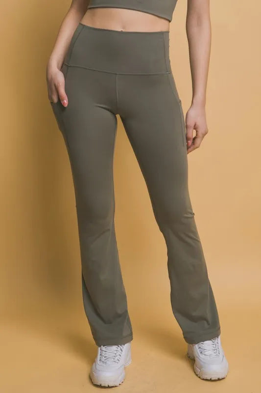 Woman wearing the Her Femme Fit High-Rise Flare Leggings in Moss