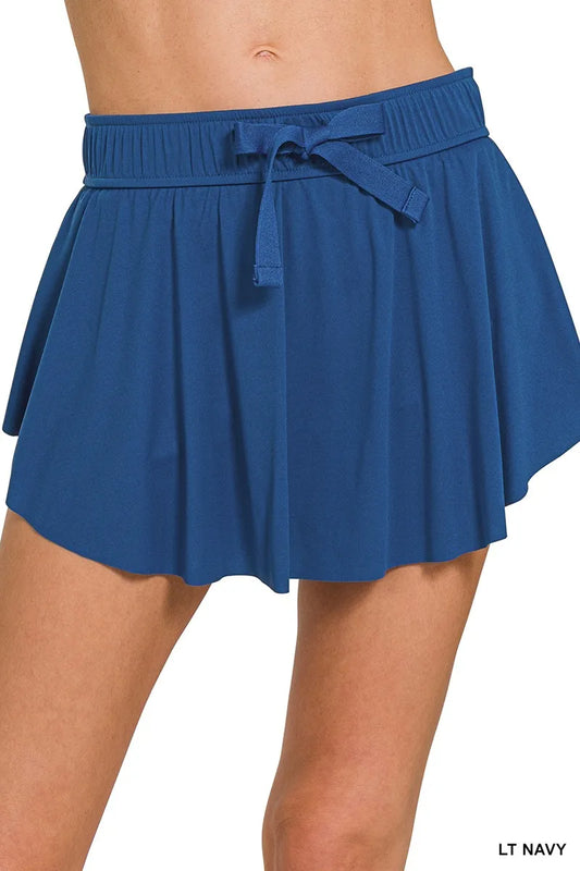 Woman wearing the Her Femme Fit Ruffle Hem Tennis Skort in Navy